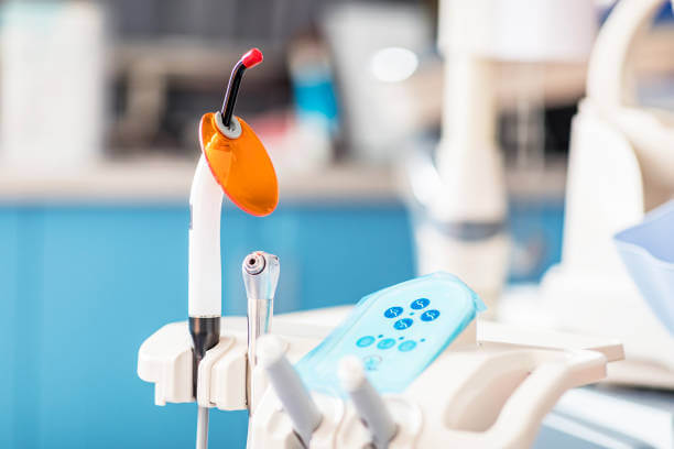 Close-up image of dentist tools and dentist's chair in the background.